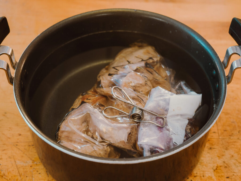 お湯の中へ豚肉パウチを投入